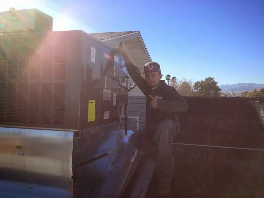 HVAC technician performing Boiler Repair on a rooftop unit in Willard